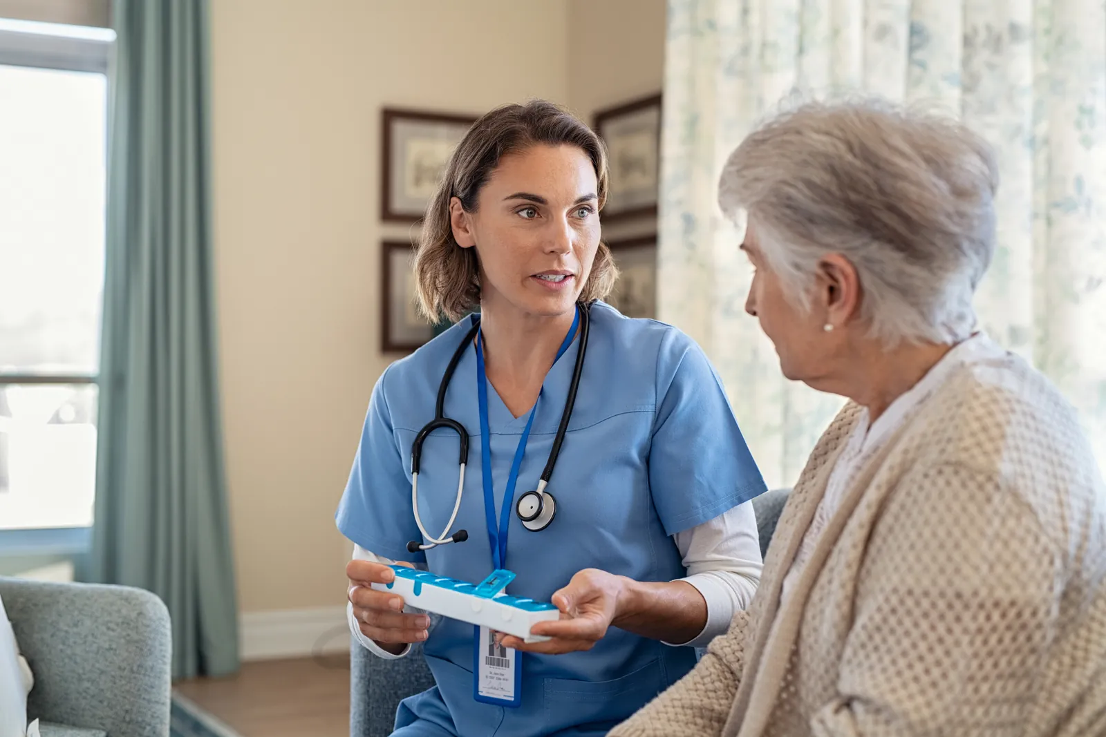 Older woman and nurse reviewing a medication schedule together